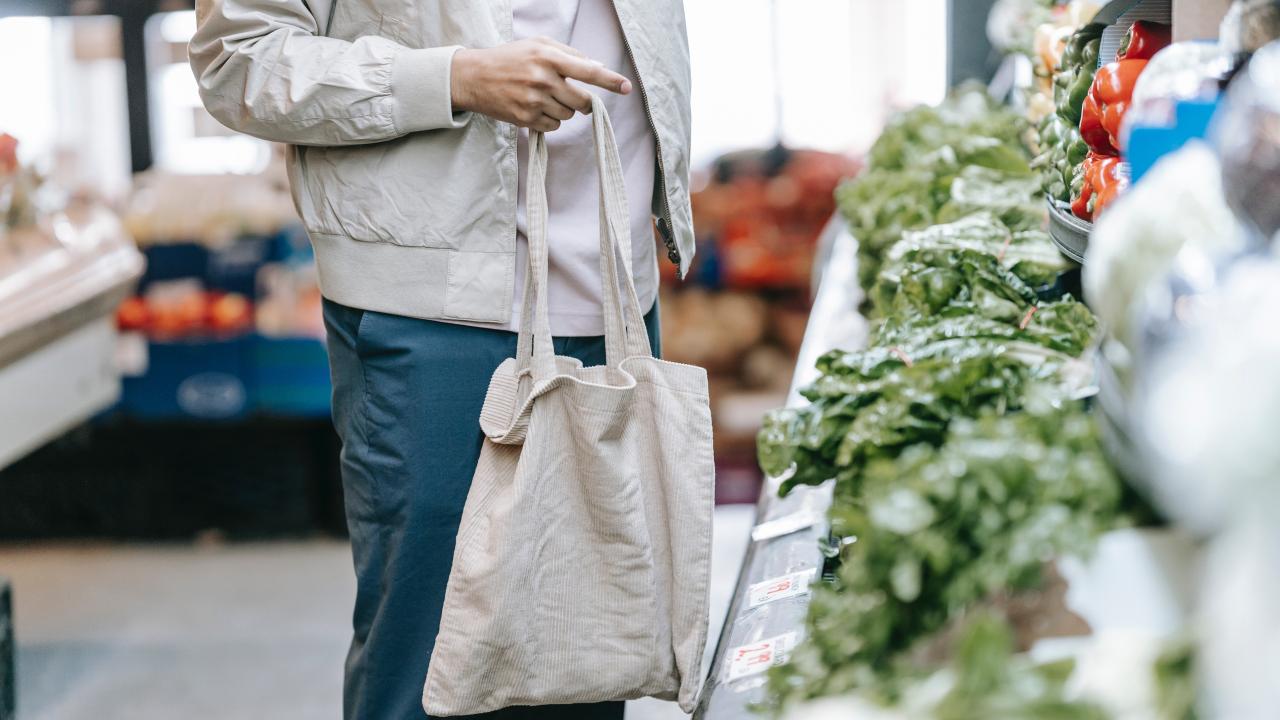 Person holding a bag shopping for groceries.