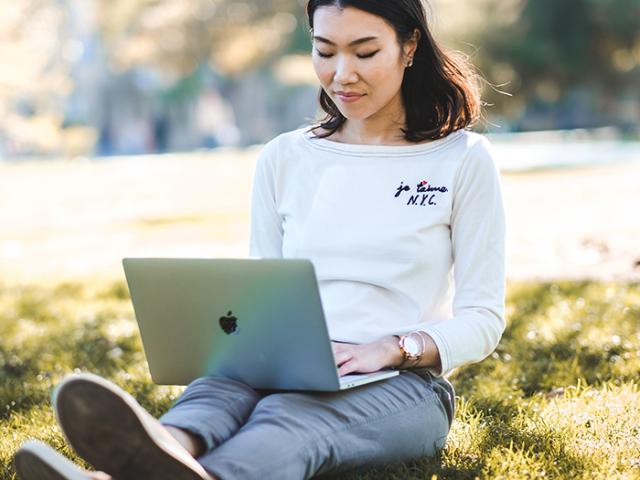 uc davis student using a laptop outdoors in the sun